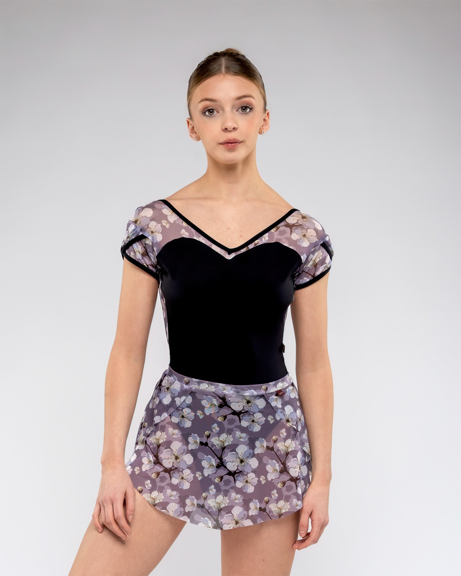 Ballet dancer wearing black ladies leotard with sweetheartt front and open low back and tulip mesh sleeve