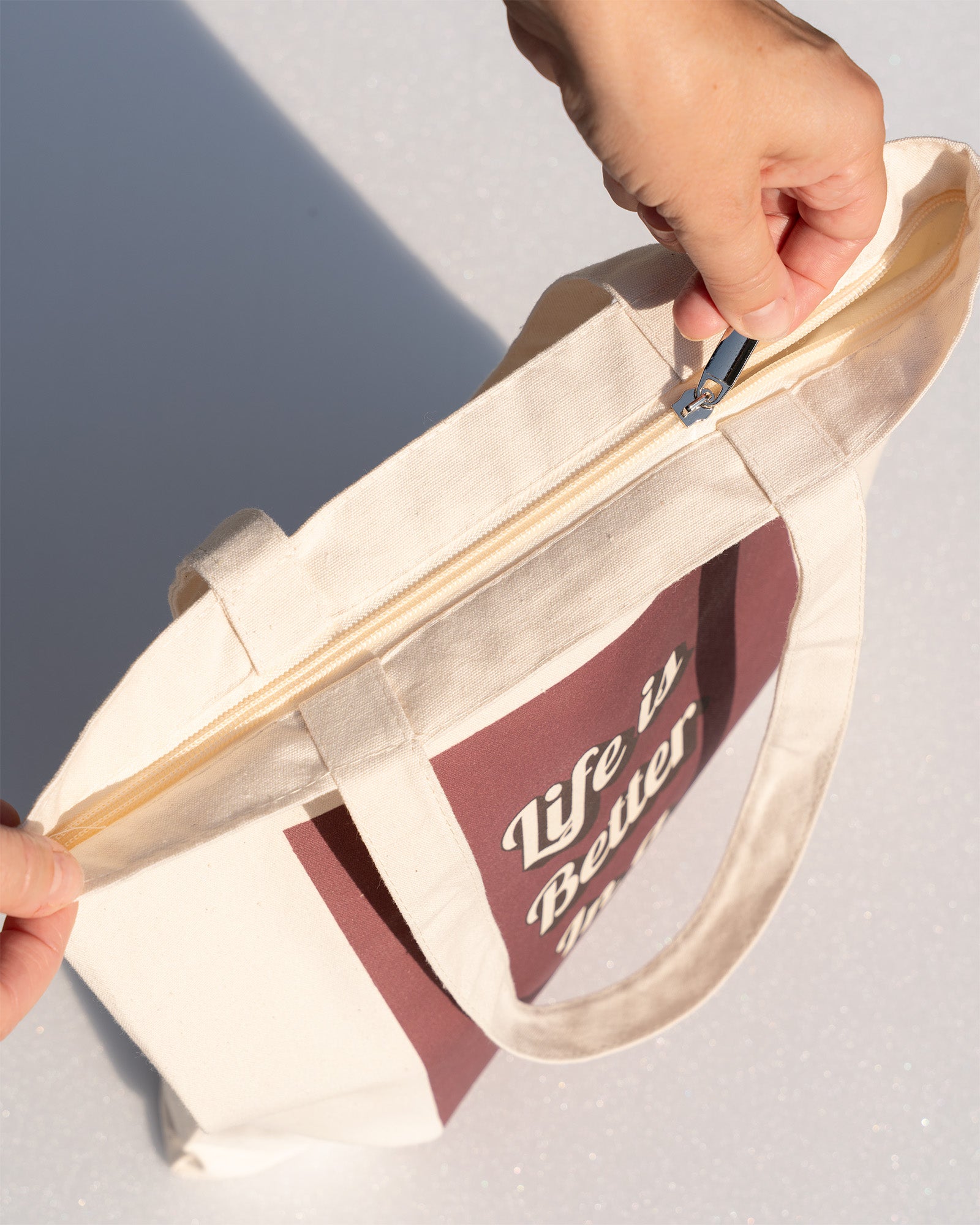 Dance bag with zipper at top held by hand.