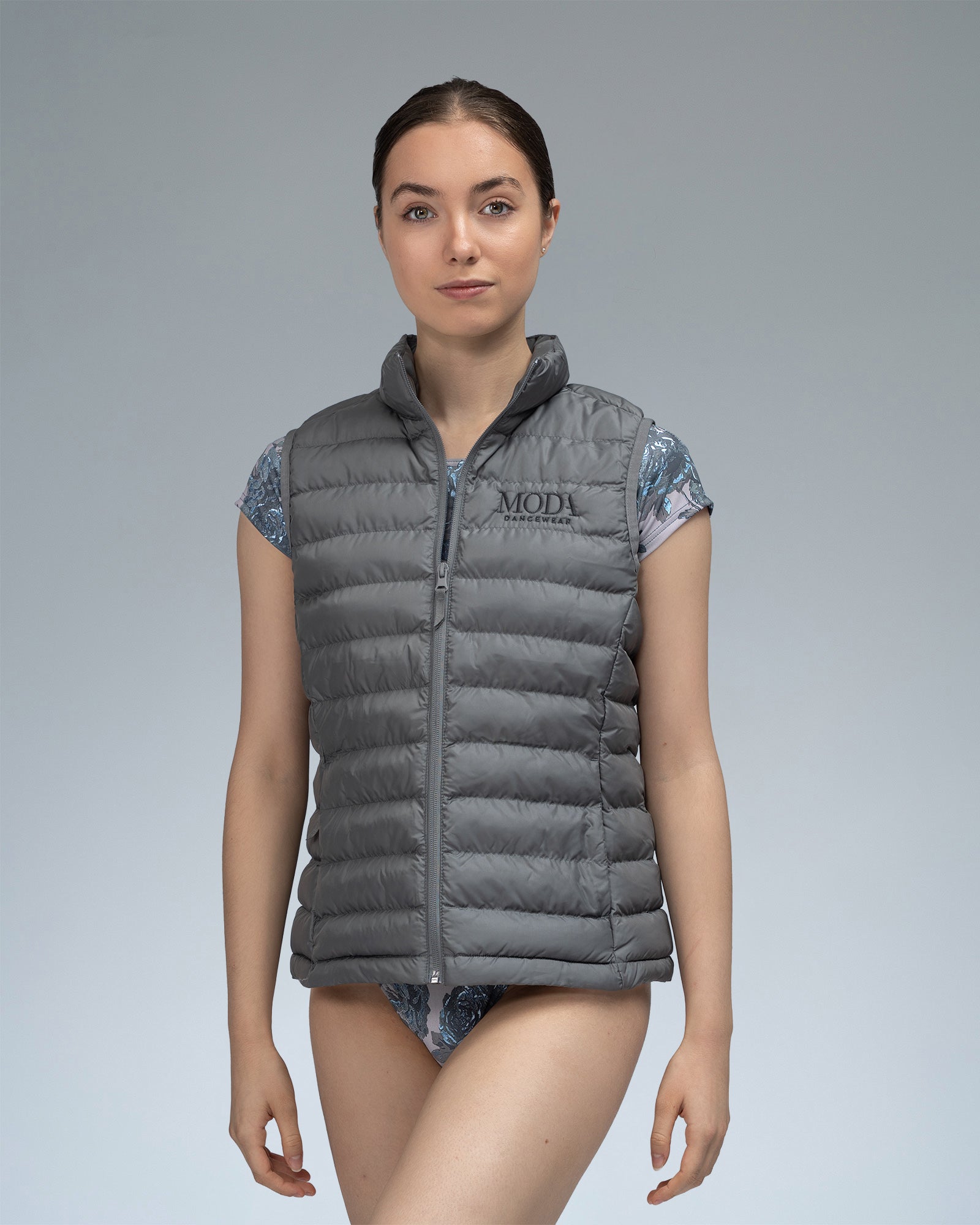 Dancer wearing a grey gilet body warmer over a leotard