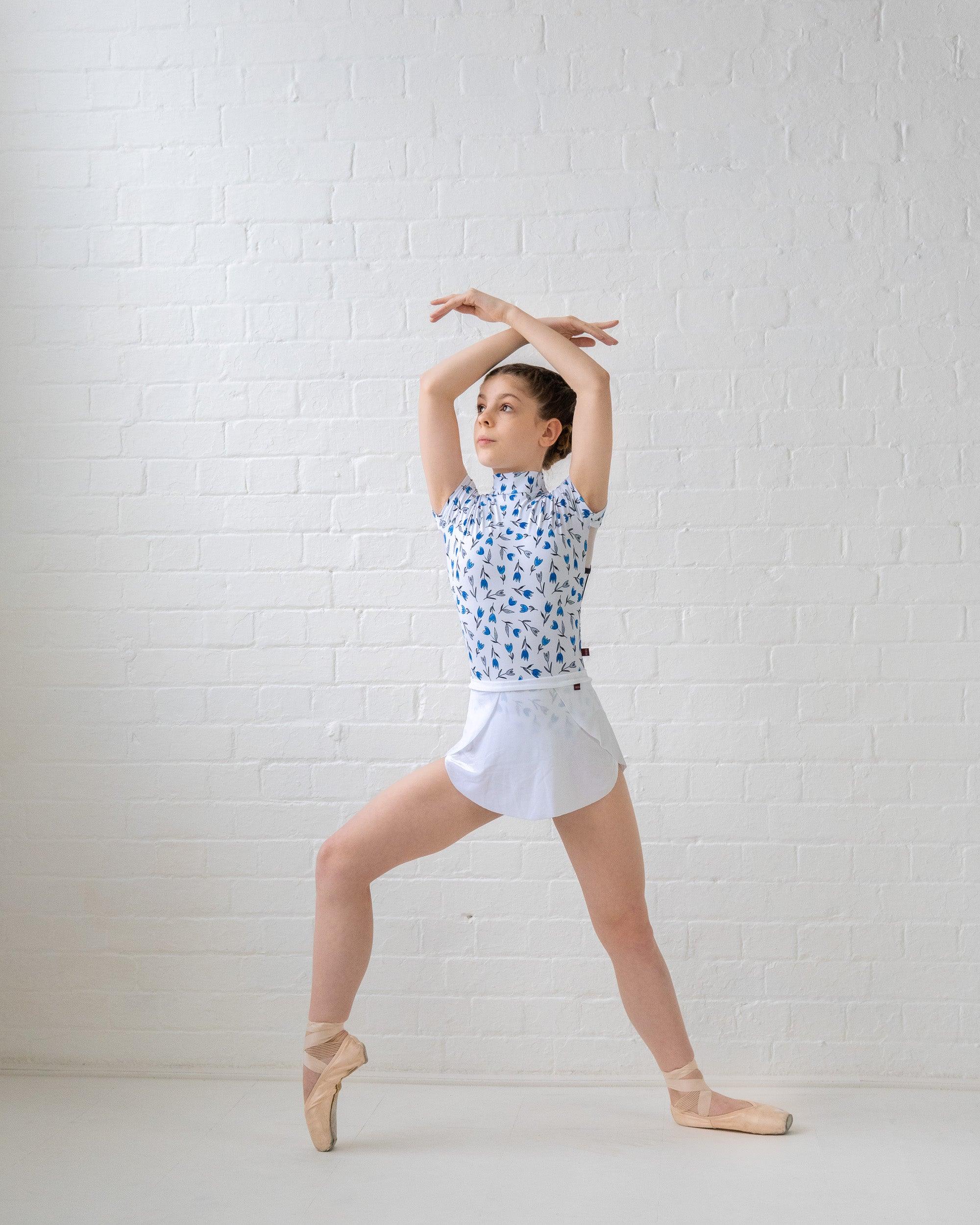 Ballet dancer on pointe wearing tulip print leotard in white black and blue with white velvet SAB skirt