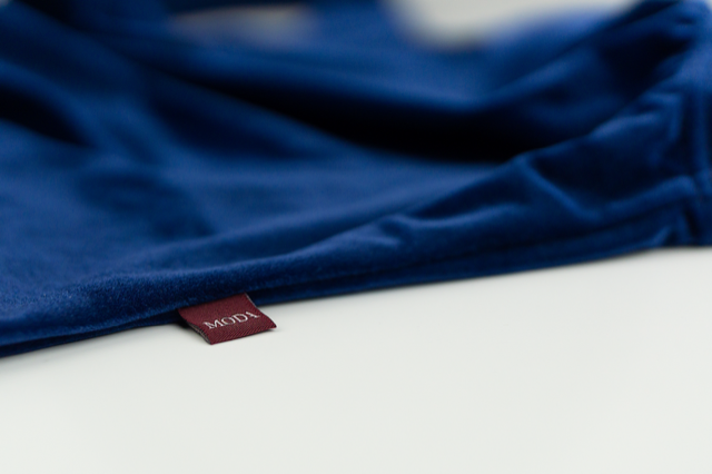 Navy blue velvet leotard on table top.