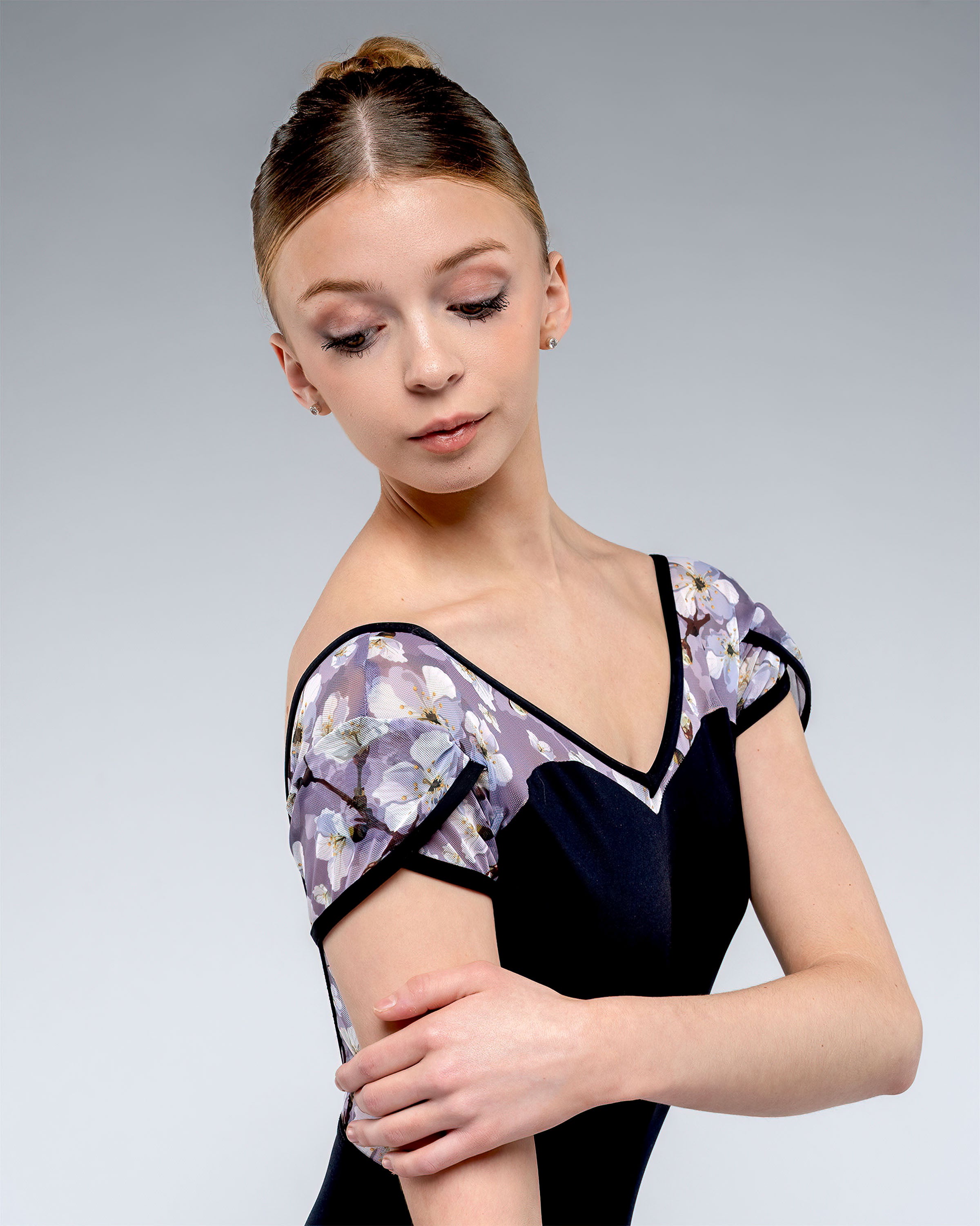 Ballet dancer wearing black ladies leotard with sweetheartt front and open low back and tulip mesh sleeve