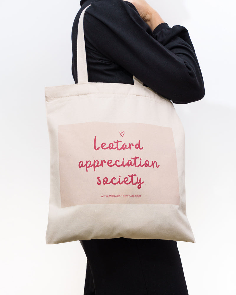 Tote bag with 'Leotard Appreciation Society' text held by a person against a white background