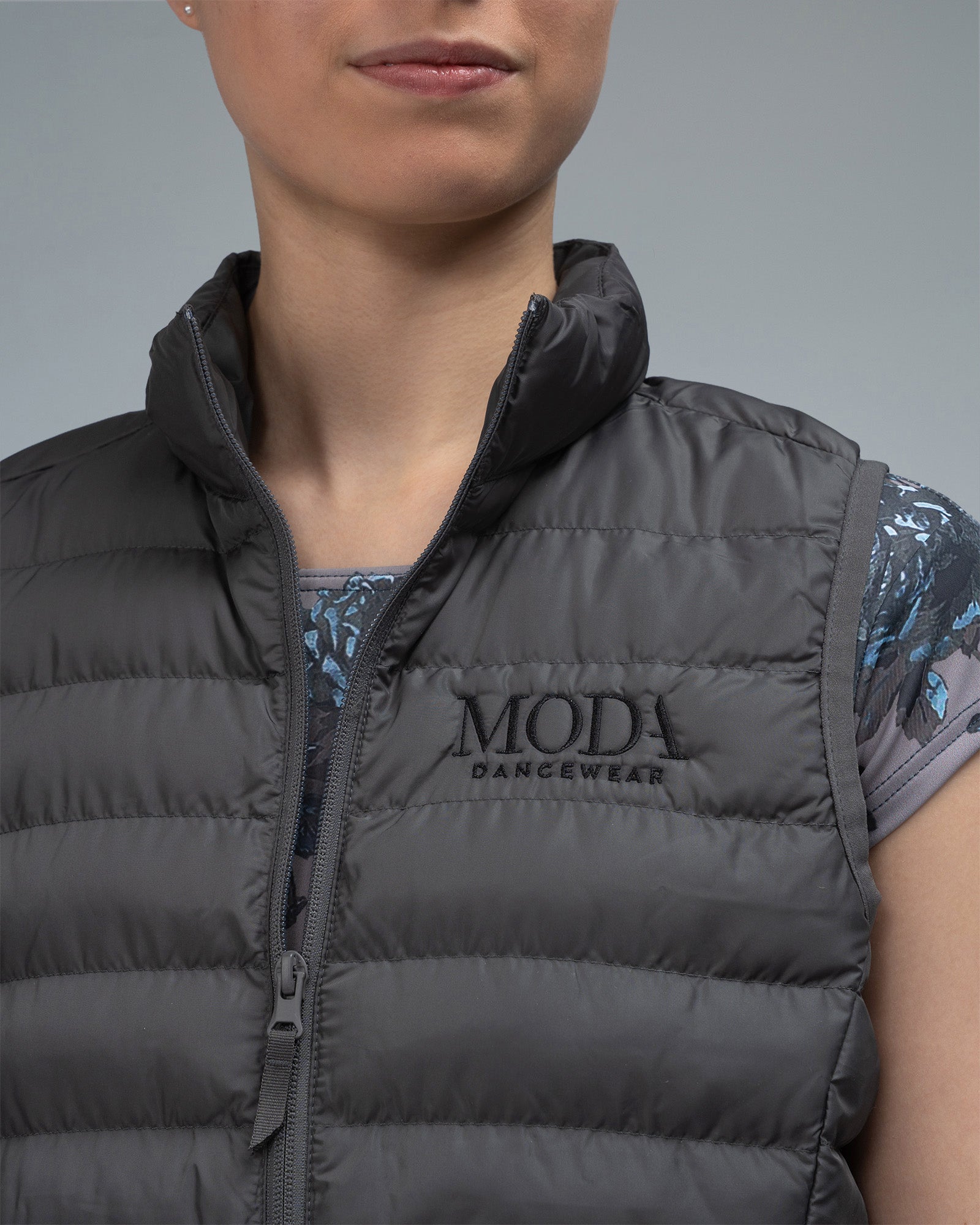 Dancer wearing a grey gilet body warmer over a leotard 